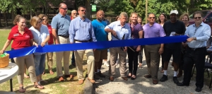 County Commissioner Don Bryant (center) cuts the blue ribbon of East Rockingham Senior Center&#039;s new walking trail.