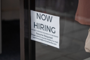 &quot;Now Hiring&quot; sign in an Asheville store window.