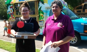 Gracie Belvins, left, is presented a Google Chromebook by Librarian Belinda Norton for reading 402 books in nine weeks, the second-most of any participant in the Young Adult division during the Hamlet Public Library&#039;s summer reading program.