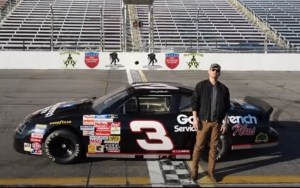 Brandon Hartt stands in front of a Dale Earnhardt car during the video for &quot;Good Years&quot; shot at Rockingham Speedway.