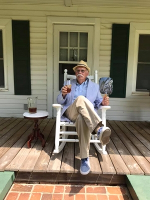 J.A. Bolton sits on a porch enjoying a glass of ice tea.