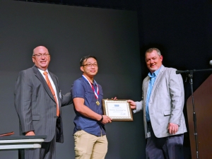 Dr. Dale McInnis, president of Richmond Community College, and Bryan Terry, program coordinator for the Electric Utility Substation &amp; Relay Technology program, present Nicholas Vue with the Academic Excellence Award for 2022.