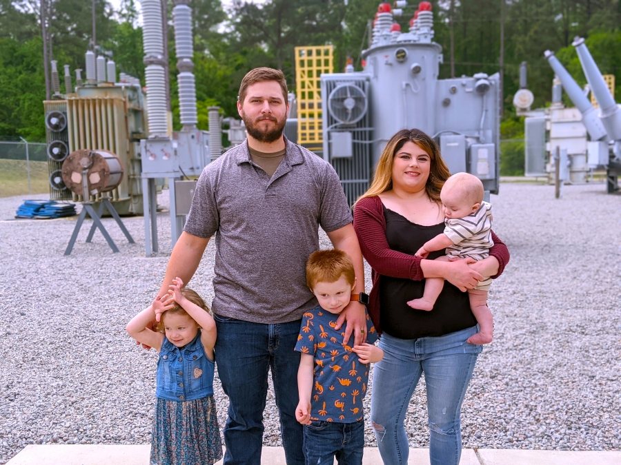  Richmond Community College student Douglas Ferrell stands with his family in the substation on the Hamlet Campus with his wife, Kathleen, and their three children. Ferrell just signed on to work for Schweitzer Engineering Laboratories as a relay technician, and his family joined him on campus for a signing celebration. 