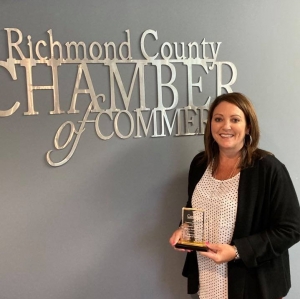 Emily Tucker, president of the Richmond County Chamber of Commerce, holds an award from the Carolinas Association of Chamber of Commerce Executives.