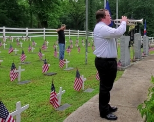 Johnny Patrick of American Legion Post 316 salutes as Cameron McDonald plays Taps during a Memorial Day service at Veterans Memorial Park late Monday morning.