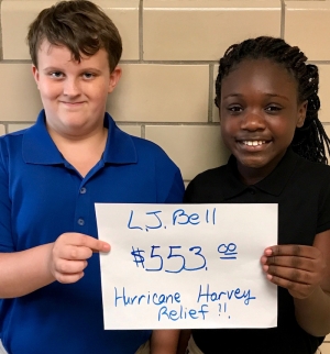 L.J. Bell students hold a sign showing how much money the school raised to support Hurricane Harvey relief efforts.