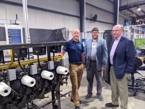 Jay Todd, chief executive officer for Service Thread, shows Dr. Dale McInnis, president of RichmondCC, a model of the new line of textile machines the company will be receiving.
