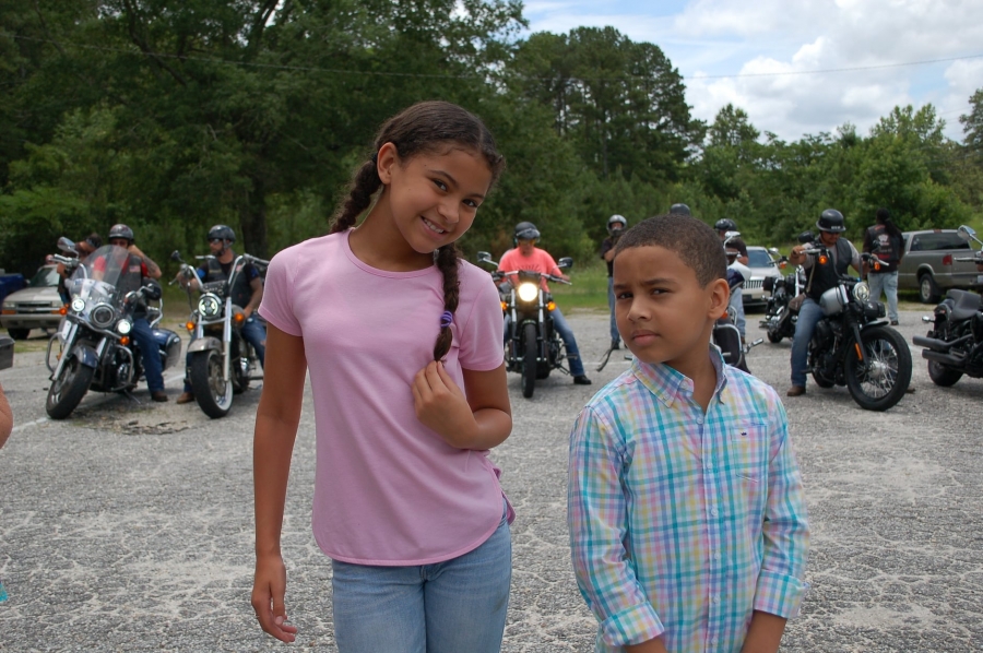 Payton and Brayden Strickland stand in front of a group of bikers about to leave Double Vision in a benefit ride on Saturday.