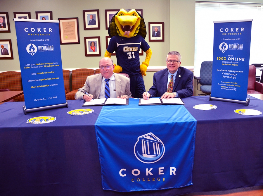 Dr. Dale McInnis, president of Richmond Community College, and Dr. Robert L. Wyatt, president of Coker College, sign the articulation agreement that creates a bridge program between the two institutions. Also attending the signing was Coker’s mascot, Striker.