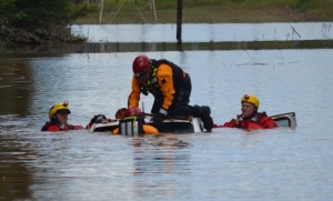 Members of a New Hampshire swiftwater rescue team check a submerged car on Blewett Falls Road to make sure no one is inside.