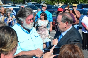 Former Arkansas governor Mike Huckabee, right, meets with T.K. Thrower during a campaign stop Wednesday in Rockingham on behalf of congressional candidate Mark Harris.