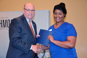 Richmond Community College nursing assistant student Tonya Smith, of Laurel Hill, shakes hand with Dr. Dale McInnis, president of the College, during the pinning ceremony held for students completing the program.